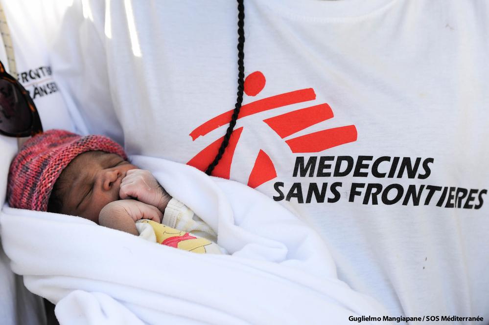 Un nouveau né dans les bras d'un membre de MSF