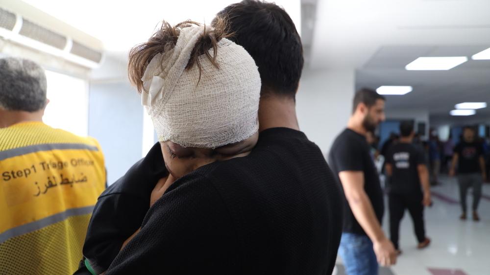 Un jeune garçon blessé par une frappe aérienne à Gaza serre son père dans ses bras après avoir été soigné à l'hôpital Al Shifa. 31 octobre 2023. © Mohammad Masri