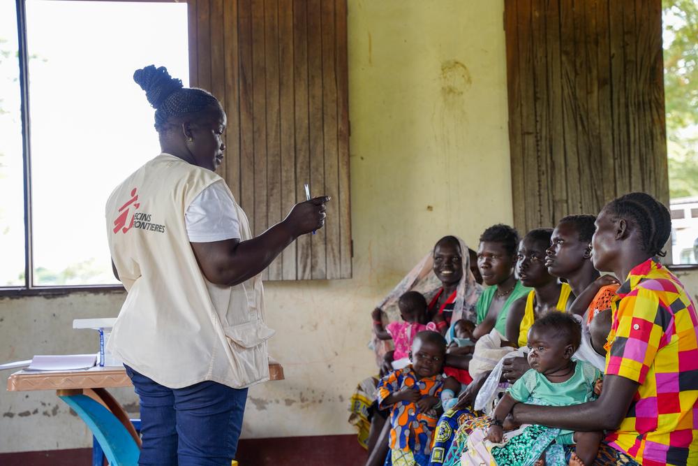 Mary Opani, éducatrice en santé communautaire, discute avec des femmes qui attendent que leur enfant soit vacciné à la clinique mobile de MSF dans le village d'Aburoto, dans le comté de Morobo, en Équatoria central. © Manon Massiat/MSF
