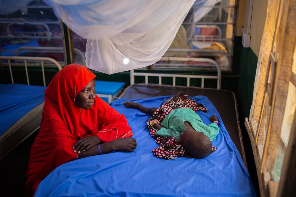 Hawa'u regarde son fils alors qu'il reçoit un traitement contre le paludisme dans la guerre pédiatrique de MSF à Gummi. État de Zamfara, Nigeria, octobre 2023. ©MSF/ALEXANDRE MARCOU