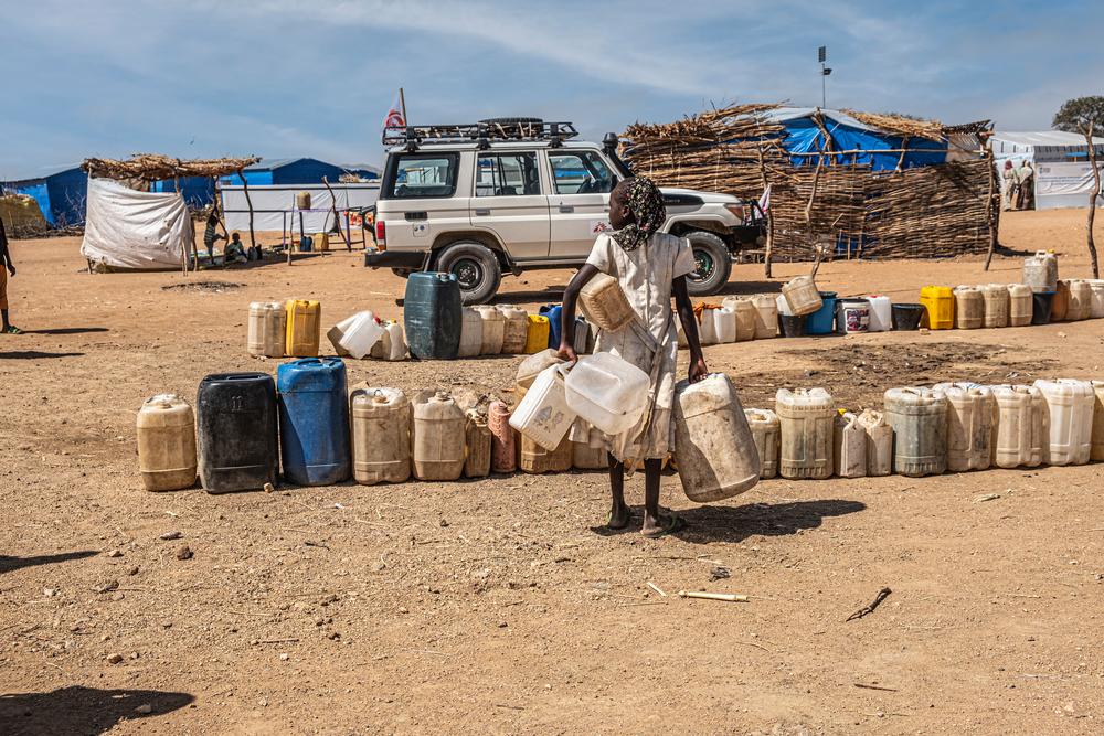Une femme à la recherche d'eau regarde la file d'attente des jerrycans qui attendent d'être remplis dans le camp de Metche, où les équipes de MSF fournissent de l'eau potable. Tchad, novembre 2023.  © Linda Nyholm/MSF