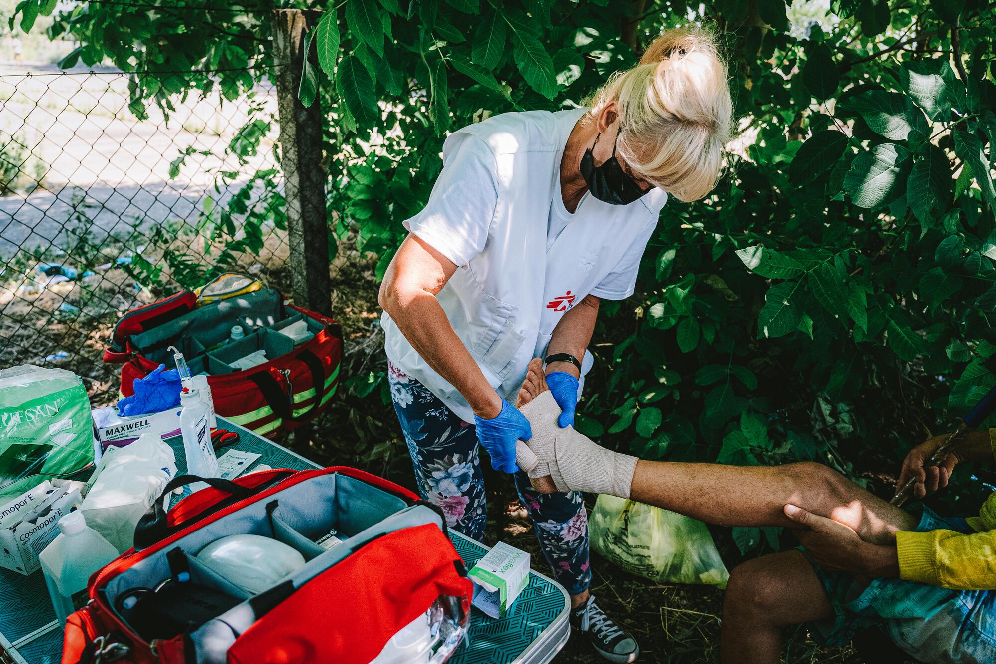 An MSF nurse straps up the ankle of a patient during a medical consultation of the MSF mobile clinic in Horgos 2 border crossing area in Serbia. 