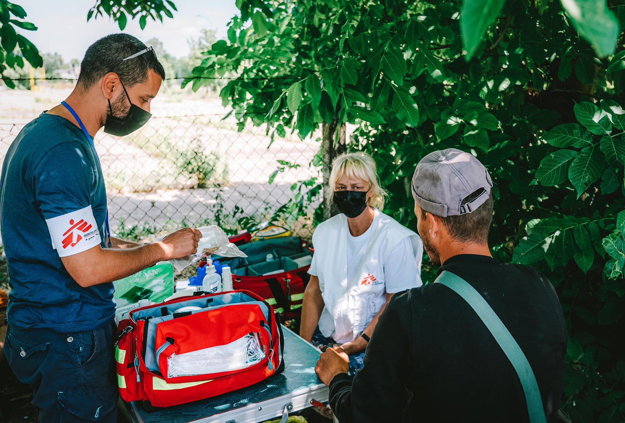 An MSF cultural mediator along with a nurse explain to a patient how to use a wound kit during a medical consultation of the MSF mobile clinic in Horgos 2 border crossing area in Serbia. 