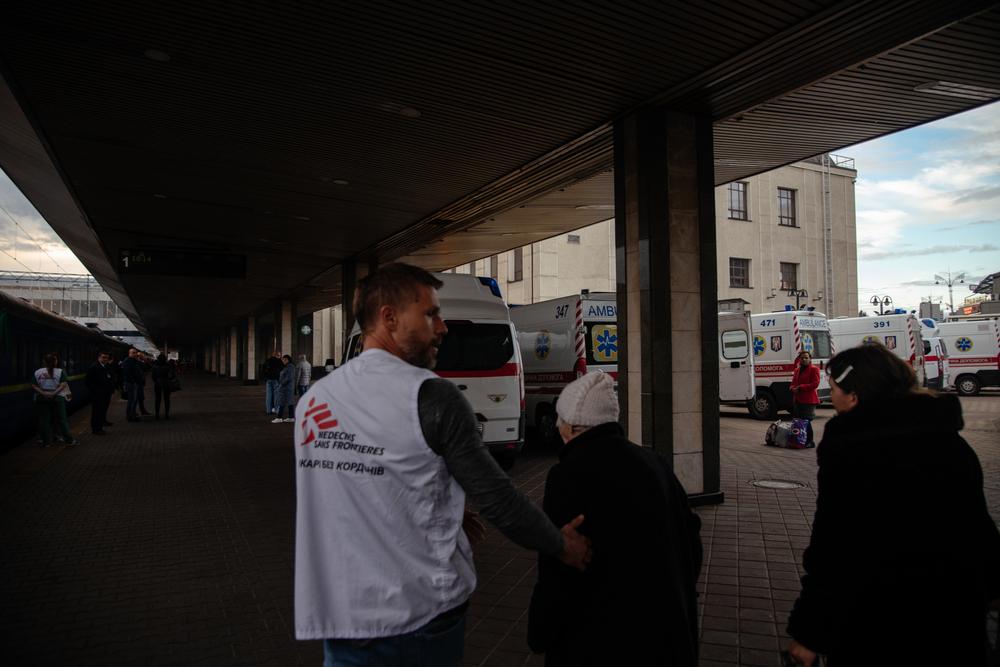 Yaroslav Vodolaga, un médecin du train médicalisé de MSF, amène un patient dans un bus qui le transportera vers un hôpital de Kiev. 