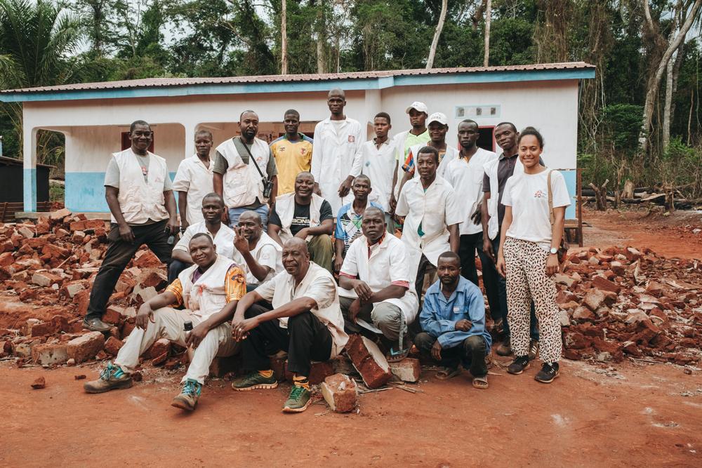 Le personnel de MSF et l&#039;équipe du poste de santé de Nganzi posent devant la nouvelle structure construite par MSF, derrière les décombres de l&#039;ancienne, préfecture de Mbomou, mars 2023.