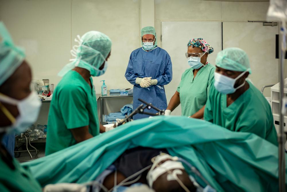 Des médecins spécialisés en traumatologie et en chirurgie vasculaire amputent un patient blessé à la jambe. 