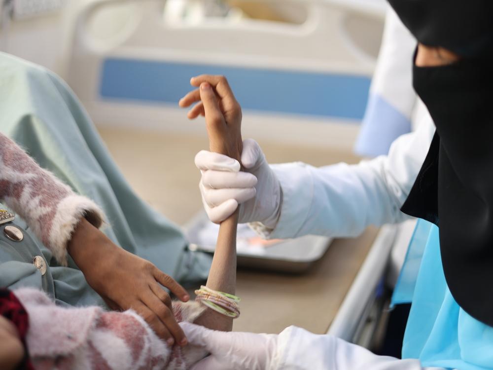 A nurse helps a malnourished child in the malnutrition ward of Khamer Al Salam Hospital. Amran, Yemen 2022. 